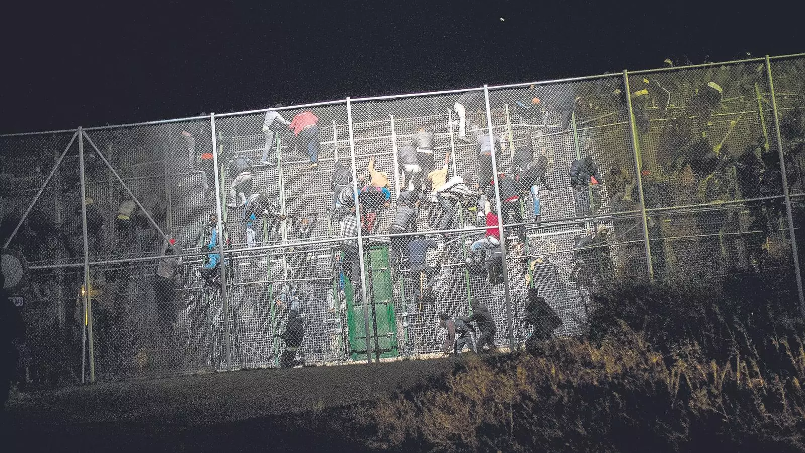 Migrants i refugiats subsaharians intenten botar la tanca que separa Nador de Melilla.