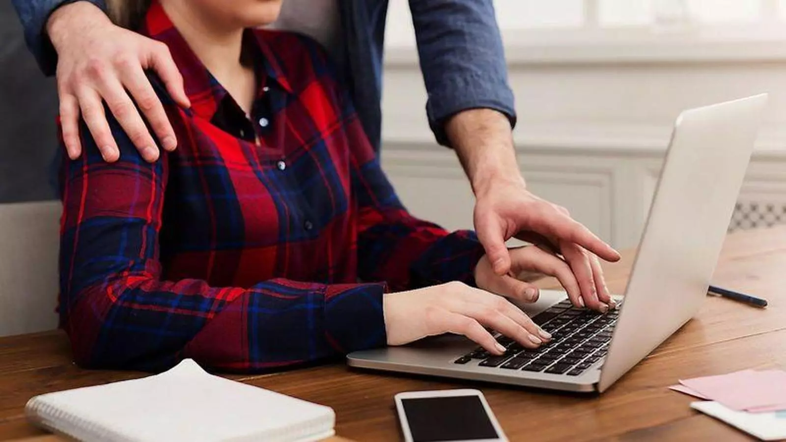 Imatge que podria suposar un assetjament sexual a una dona en l’àmbit laboral.