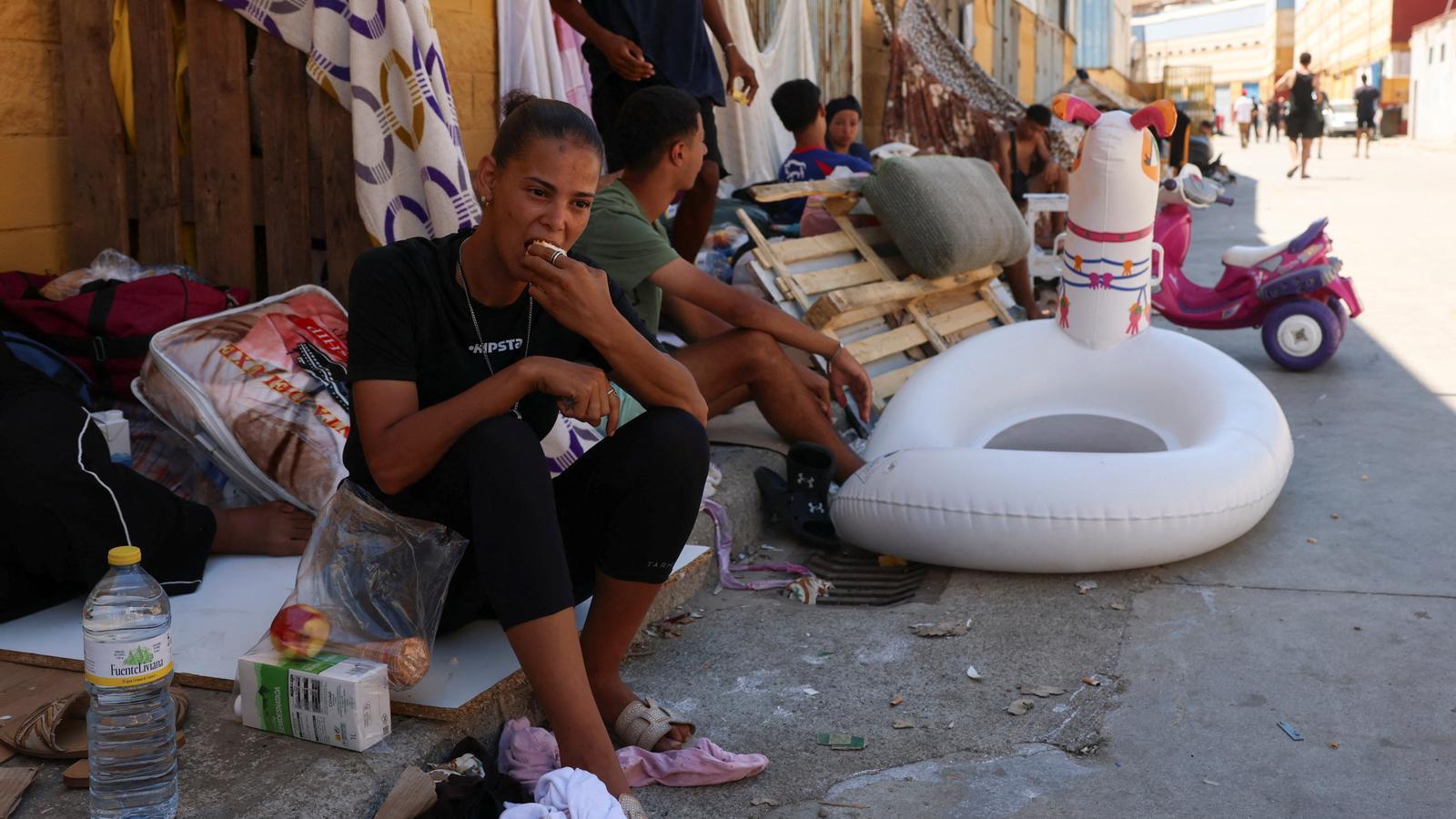 Fatiha and other migrants sit in the shade after having crossed from Morocco to Spanish territory, in Ceuta, Spain.