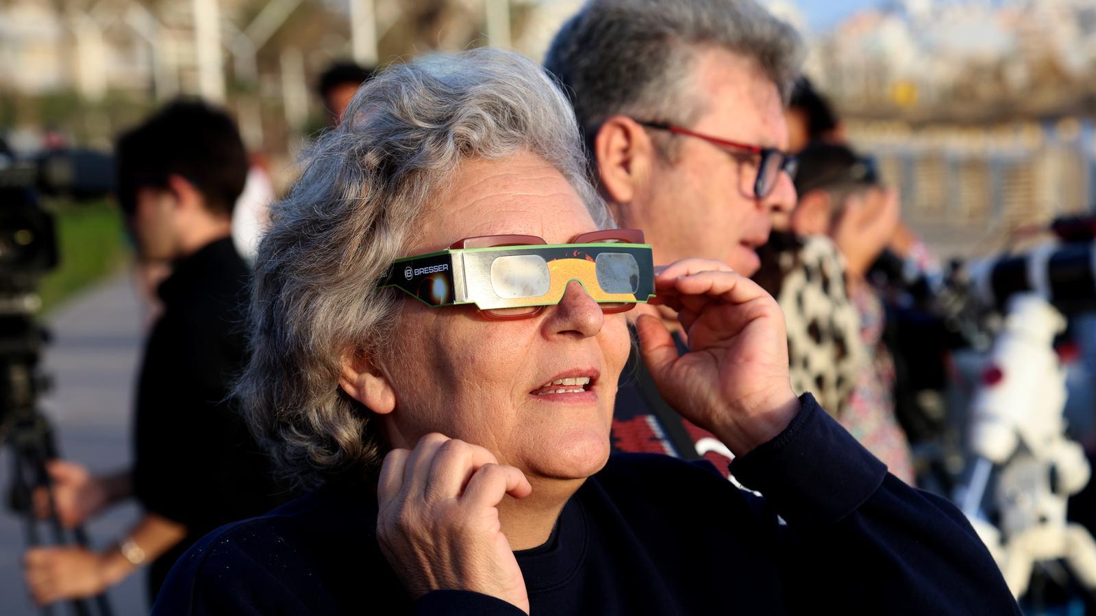 Eine Frau mit Brille, um die Sonnenfinsternis zu sehen.