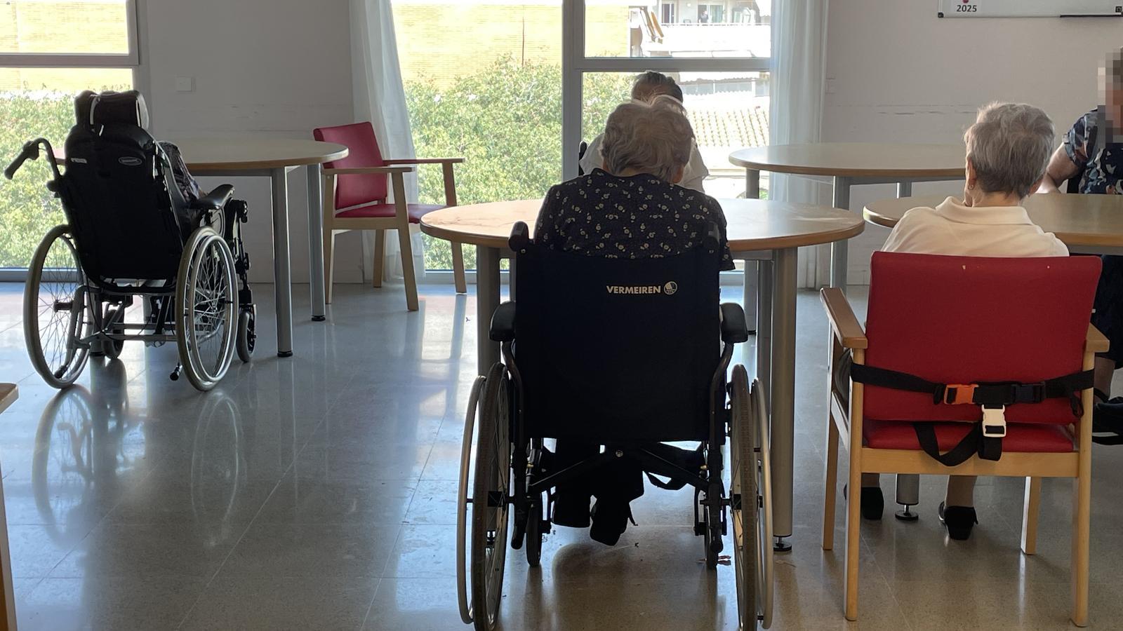 Several elderly people in the living-dining room on the third floor of the Alchemika residence in Barcelona.