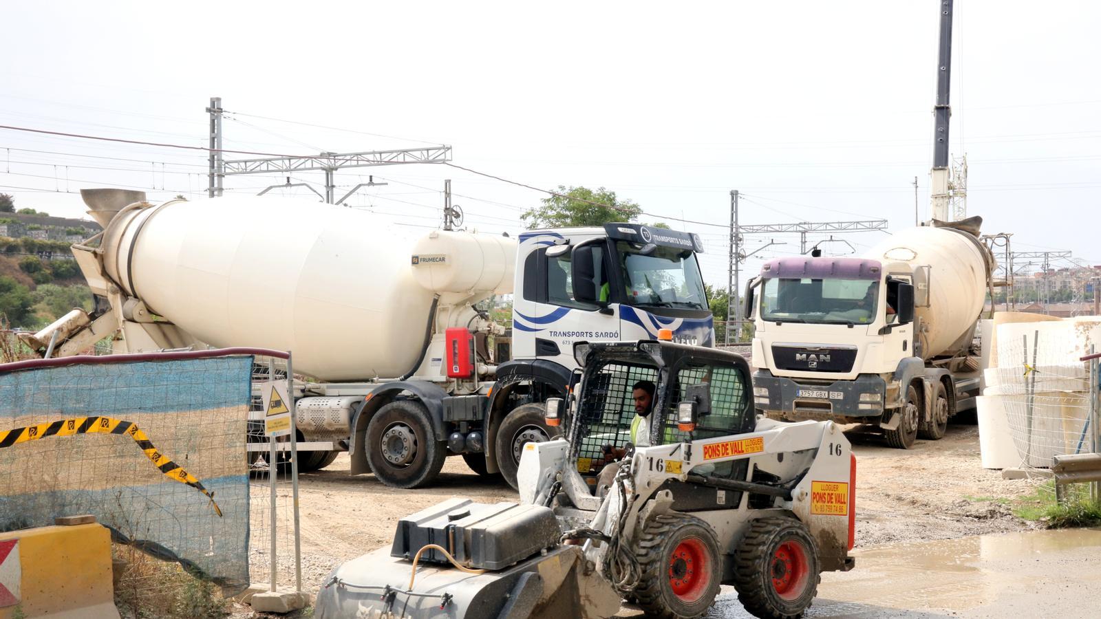 Workers working with machinery in the area affected by the Montcada landslide