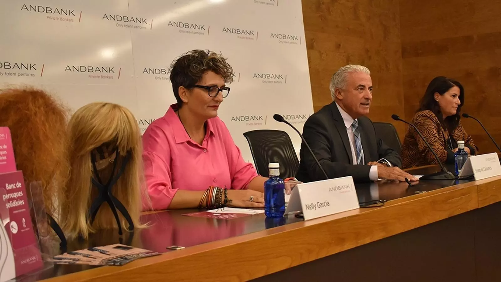 La directora de la perruqueria i centre d'estètica Kerala, Nelly García; el subdirector general de banca país d'Andbank, Josep Maria Cabanes i la directora de banca país d'Andbank, Maria Suárez, durant la presentació del banc de perruques.