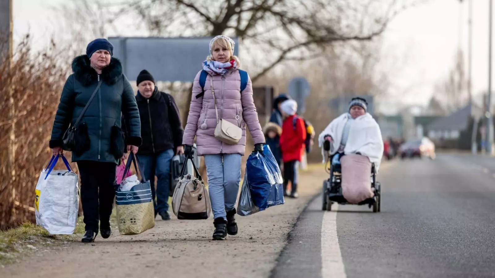 Persones caminant amb les seves pertinences ja a Hongrïa, deixant enrere al frontera ucraïnesa