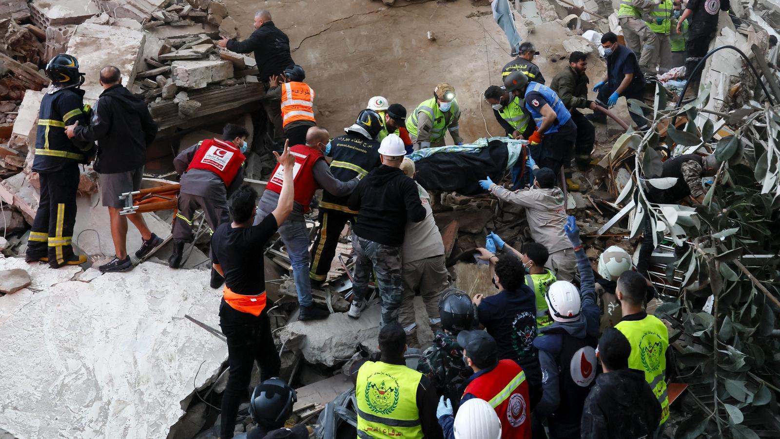 Servicios de rescate llevan el cuerpo de una víctima tras un ataque aéreo israelí, en el barrio de Tallet al-Khayat de Beirut, Líbano.