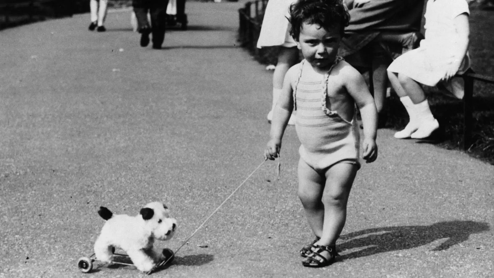 Una foto antiga d'una nena petita amb un peluix.