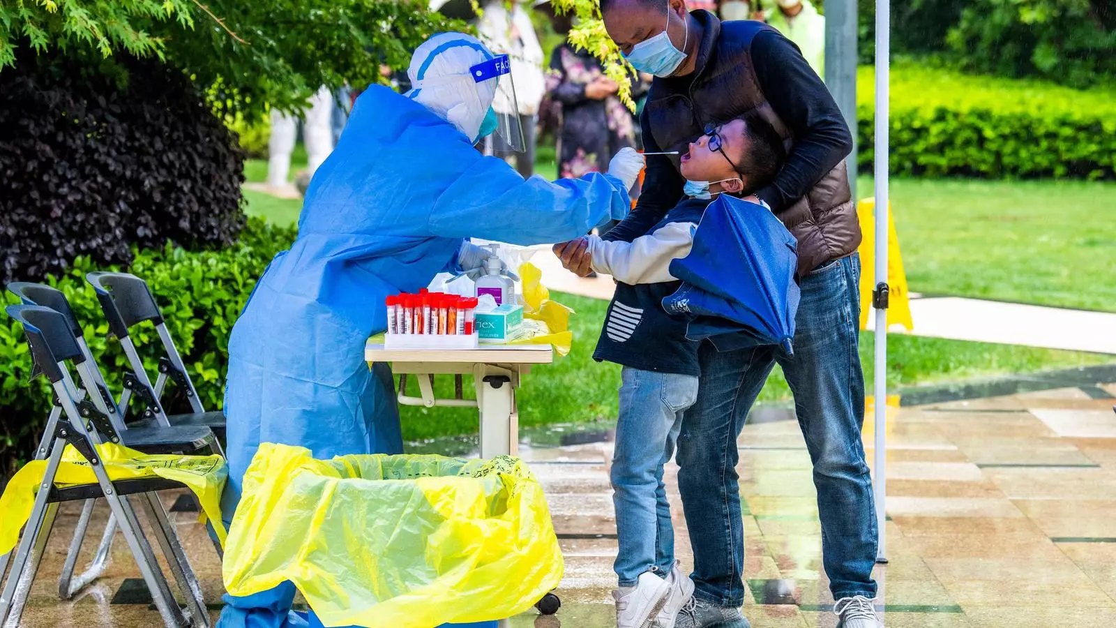 Una treballadora sanitària fa una PCR a un nen a Xangai.