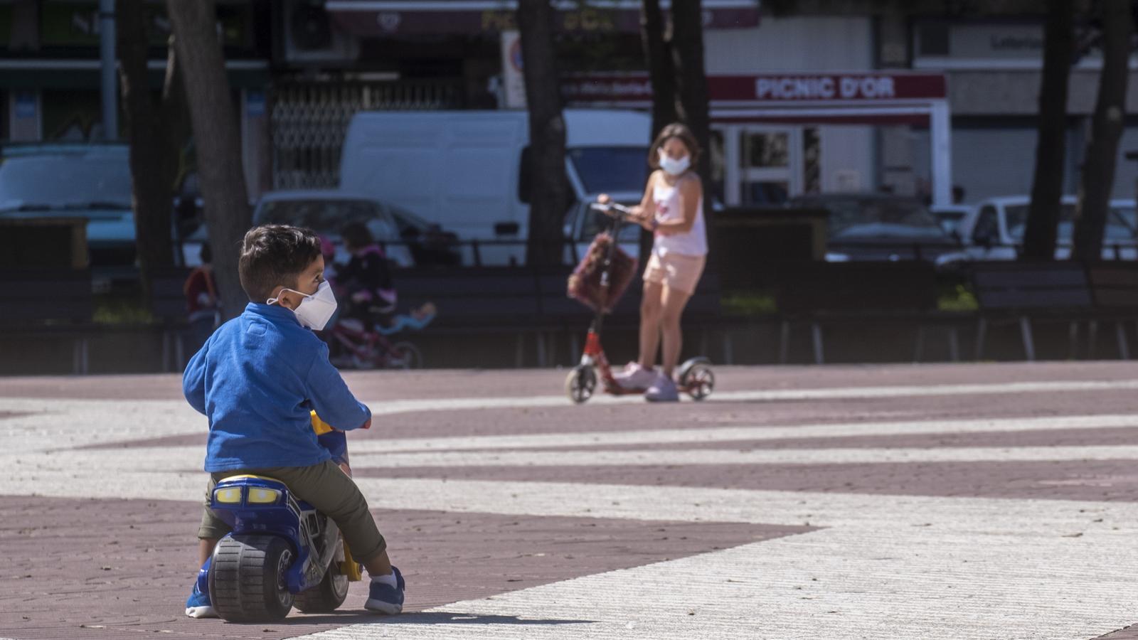 Criatures jugando en la calle con mascarilla