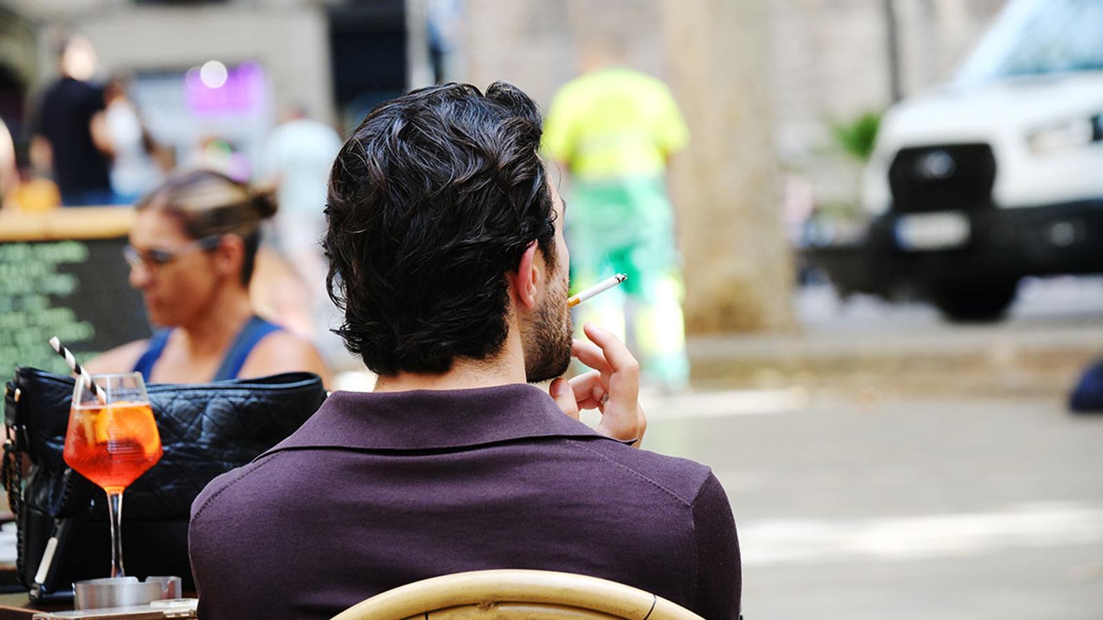 A boy smoking on a terrace of a bar in Barcelona