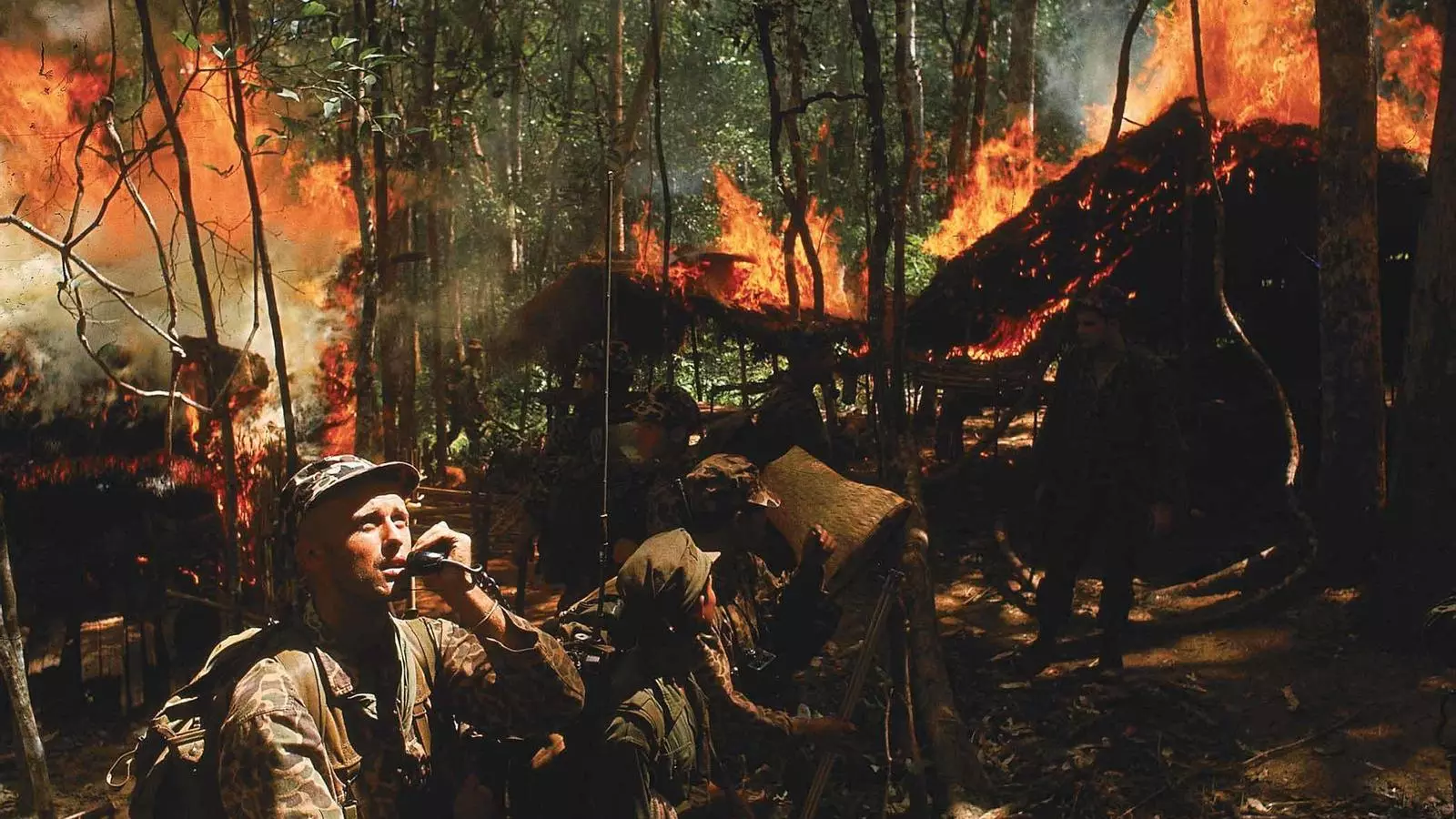 El capità de Forces Especials de l’exèrcit dels Estats Units Vernon Gillespie contactant per ràdio amb el seu camp base mentre soldats vietnamites cremen el seu amagatall