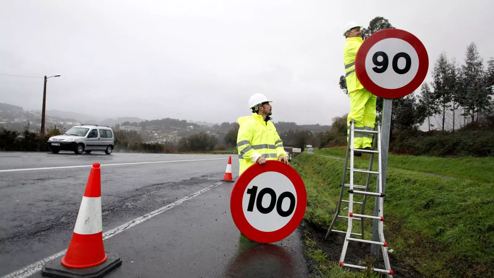 Dos operaris retiren l'última senyal a Galícia de velocitat màxima permesa a les vies convencionals i la substitueixen per la nova limitació de 90 km/h