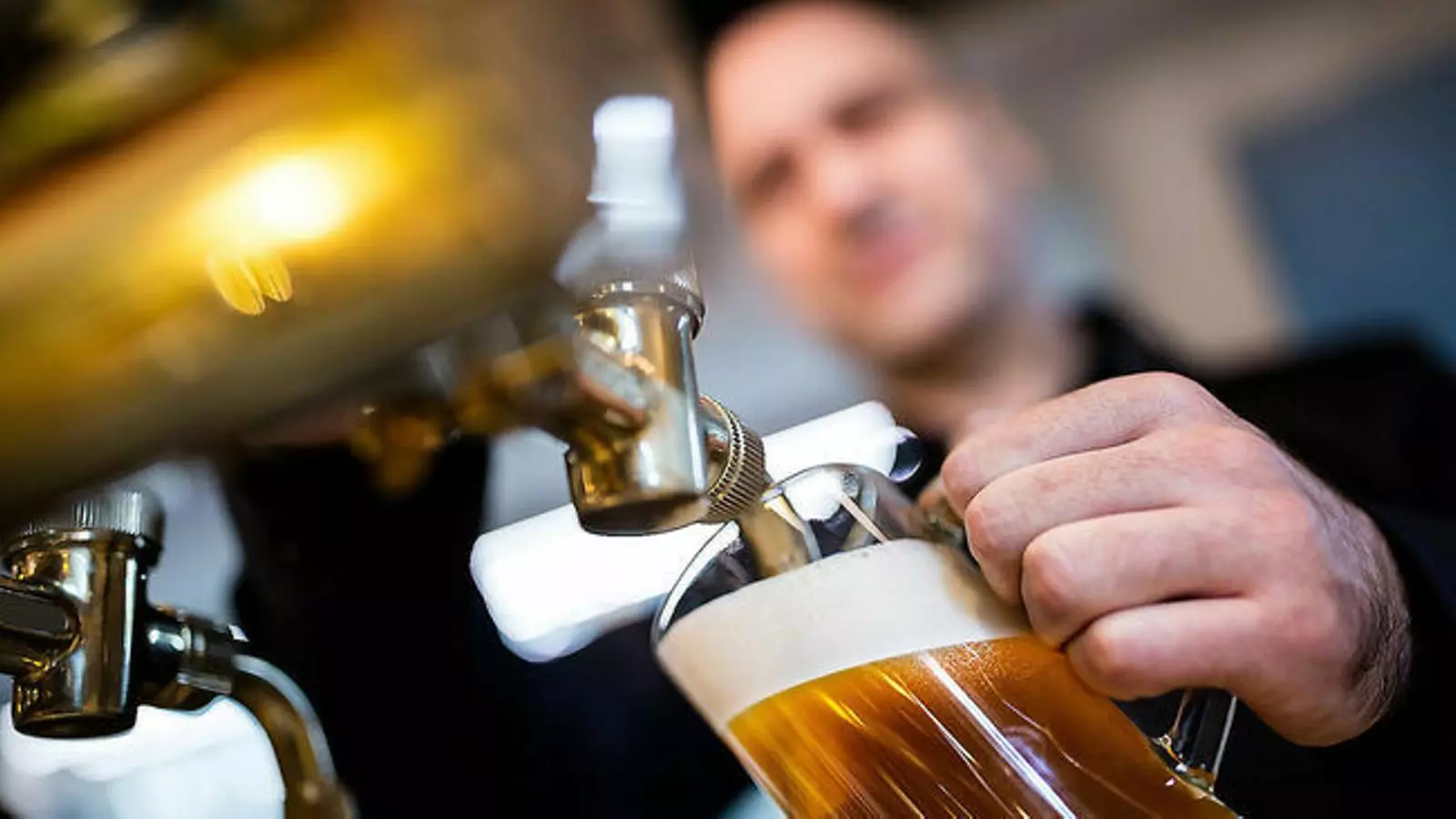 Un cambrer omplint una gerra de cervesa / GETTY