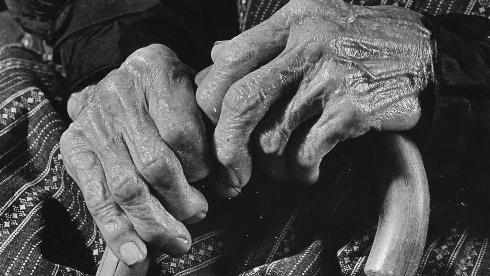 Las manos de una mujer grande sujetan un bastón que la ayuda a andar.