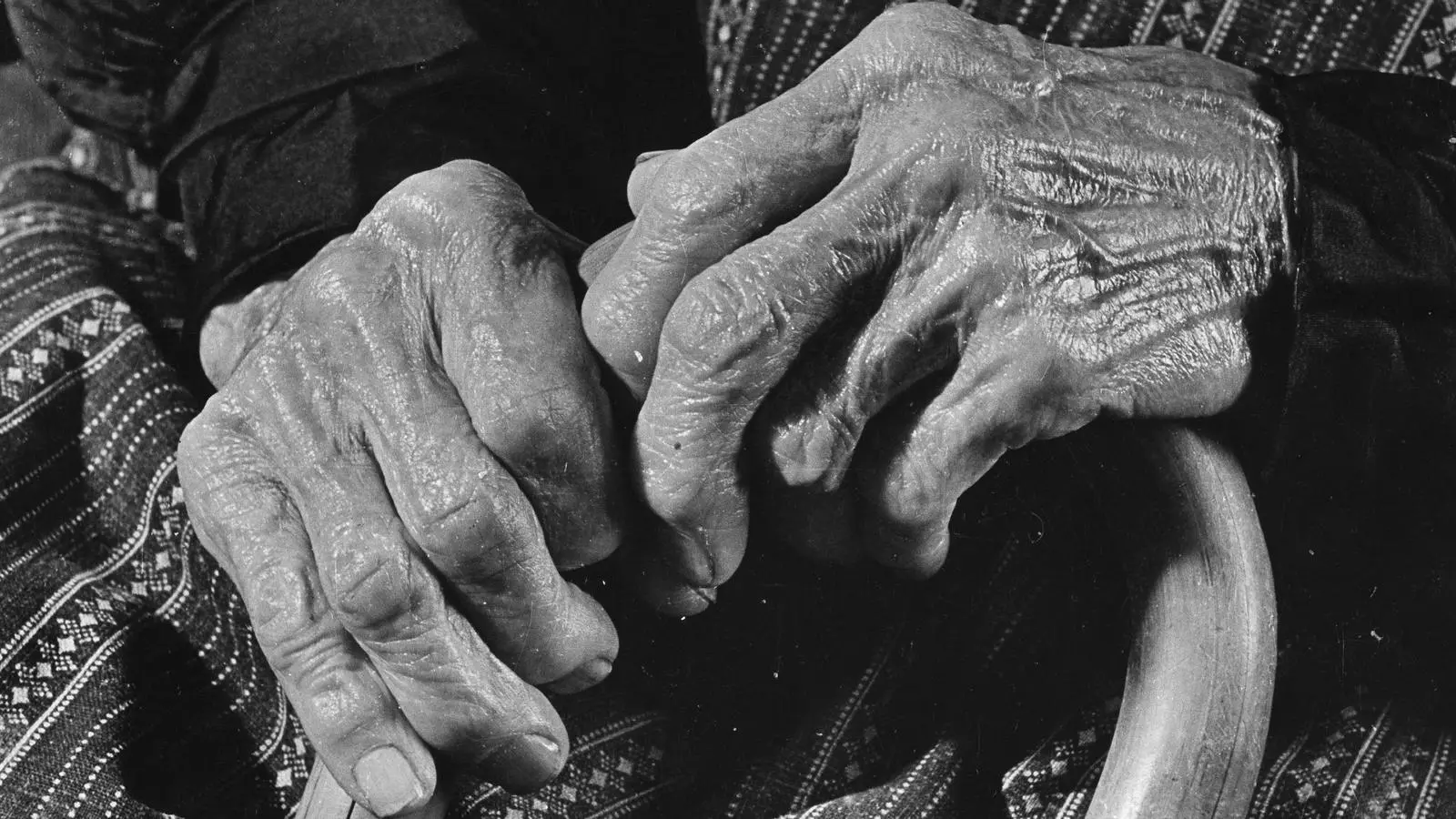 Les mans d'una dona gran subjecten un bastó que l'ajuda a caminar.