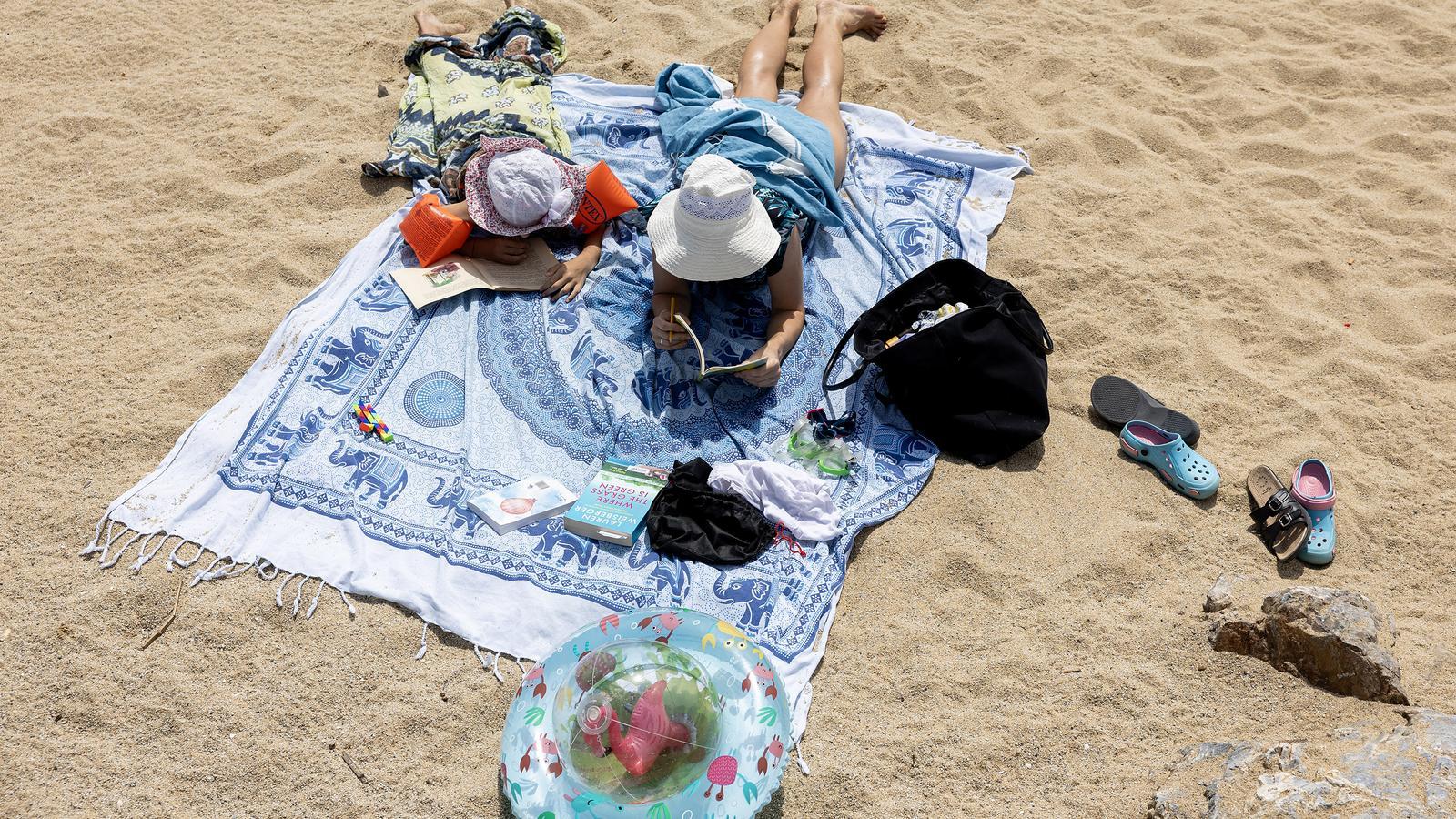 A mother with her daughter on a Catalan beach.