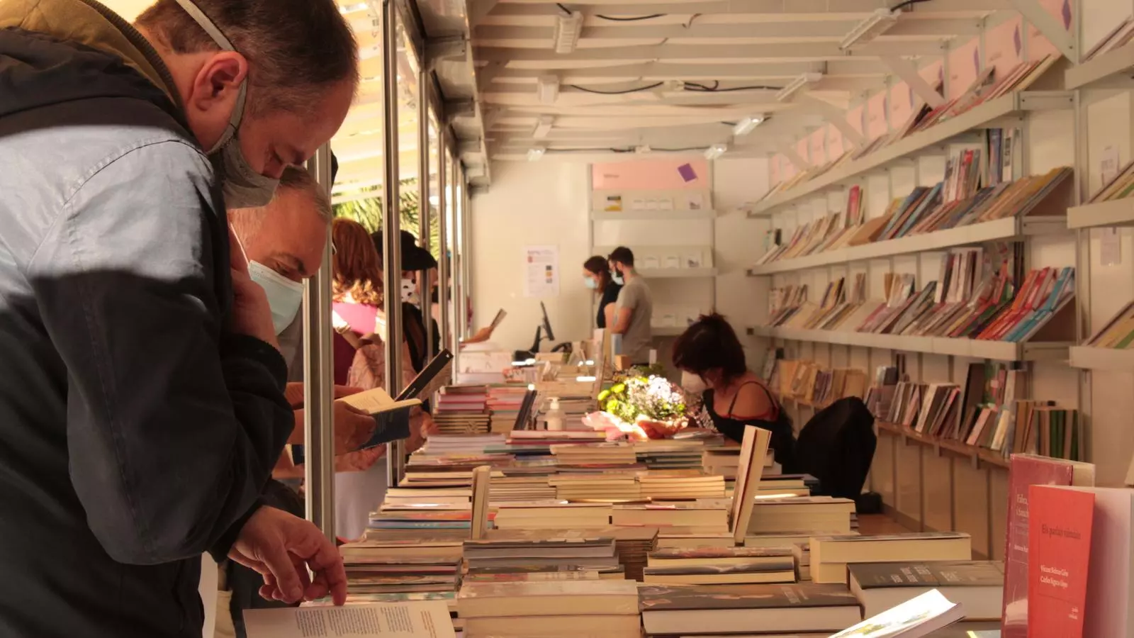 Diverses persones visiten un dels estands de la 8a edició de la Plaça del Llibre de València