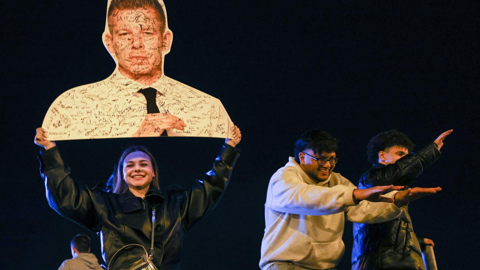 Seguidores de Tisza celebran los resultados en las elecciones de Hungría con un cartel con la cara de Péter Magyar.