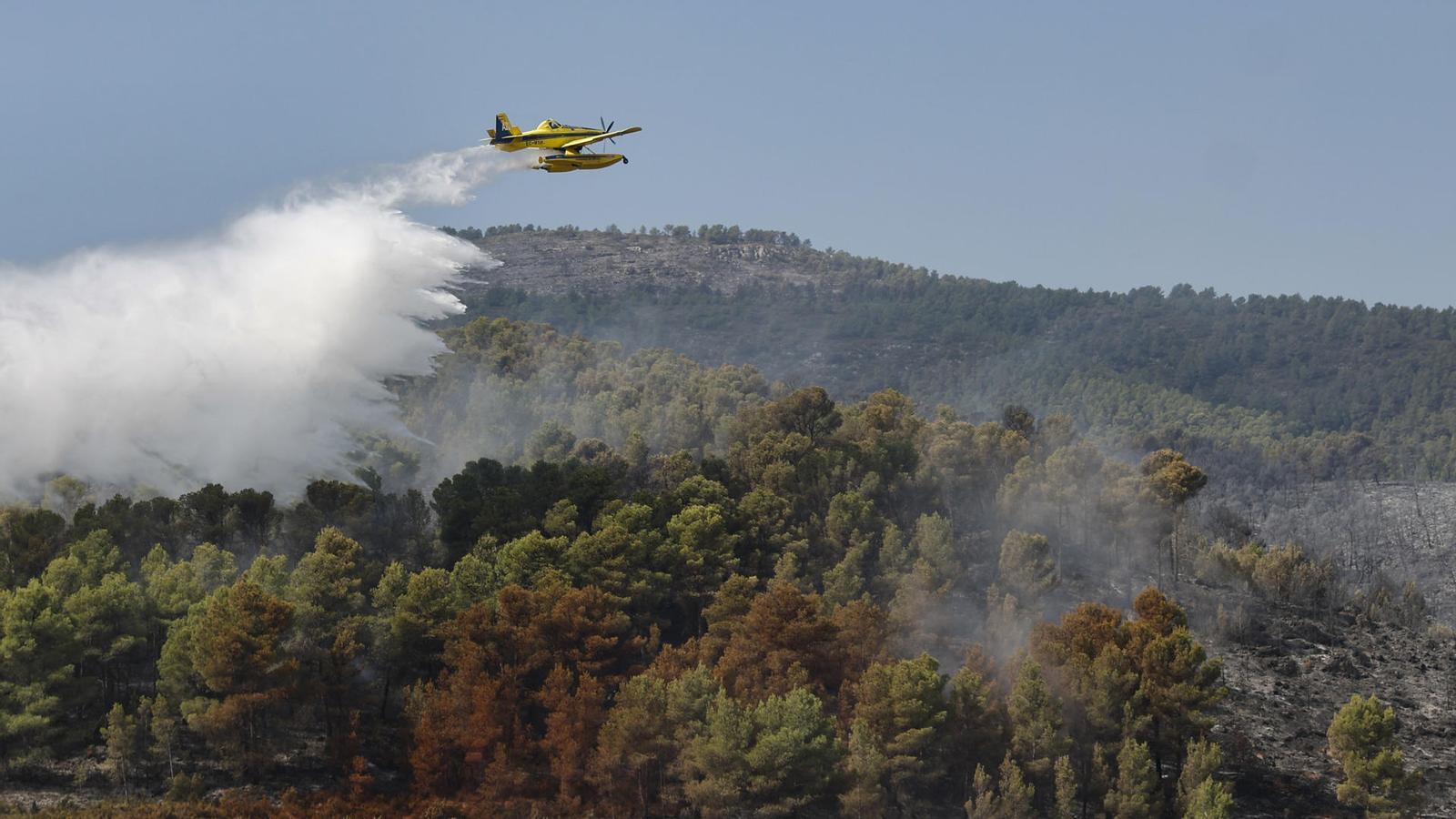 Una avioneta durante las tareas de extinción del incendio que afecta a la localidad valenciana de Tuéjar.