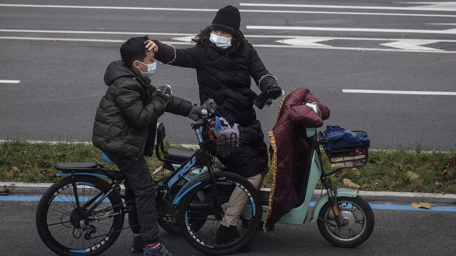 Una dona comprova si el seu fill té febra a Wuhan, Xina