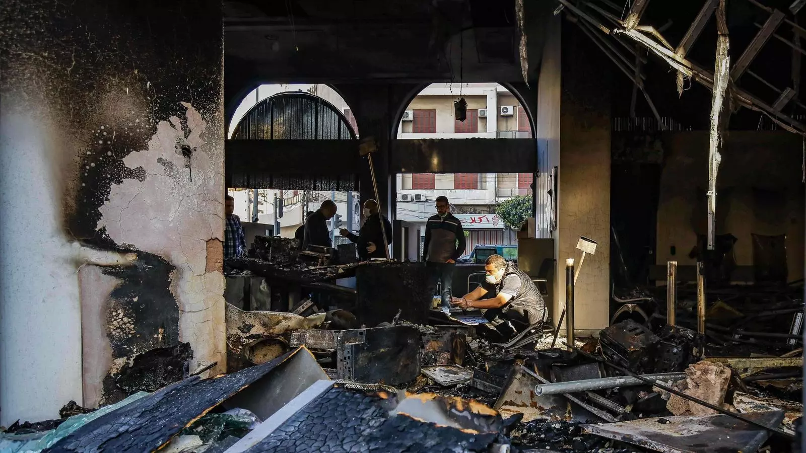 Un grup de persones entren en un banc destrossat després d'una manifestació a Trípoli, Líbia