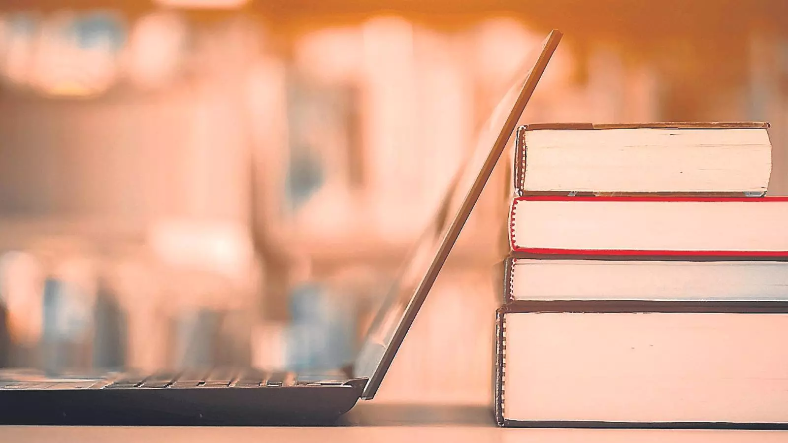 Un ordinador portàtil al costat de diversos llibres
