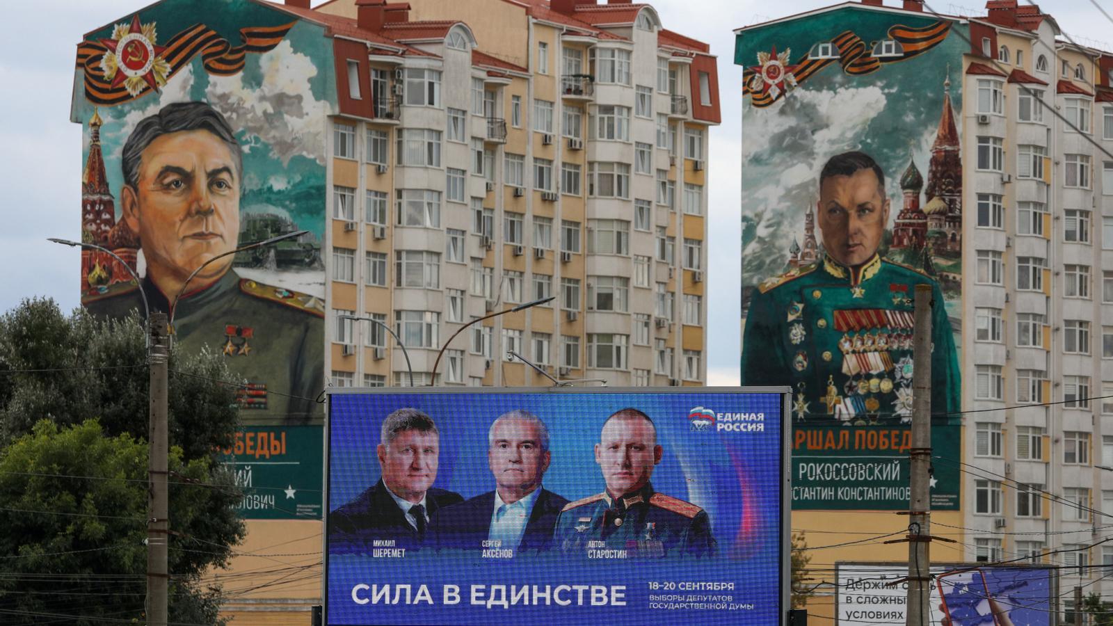 A screen promoting the United Russia party in front of buildings with murals of Soviet military commanders in Simferopol, Crimea, on September 15, 2026.