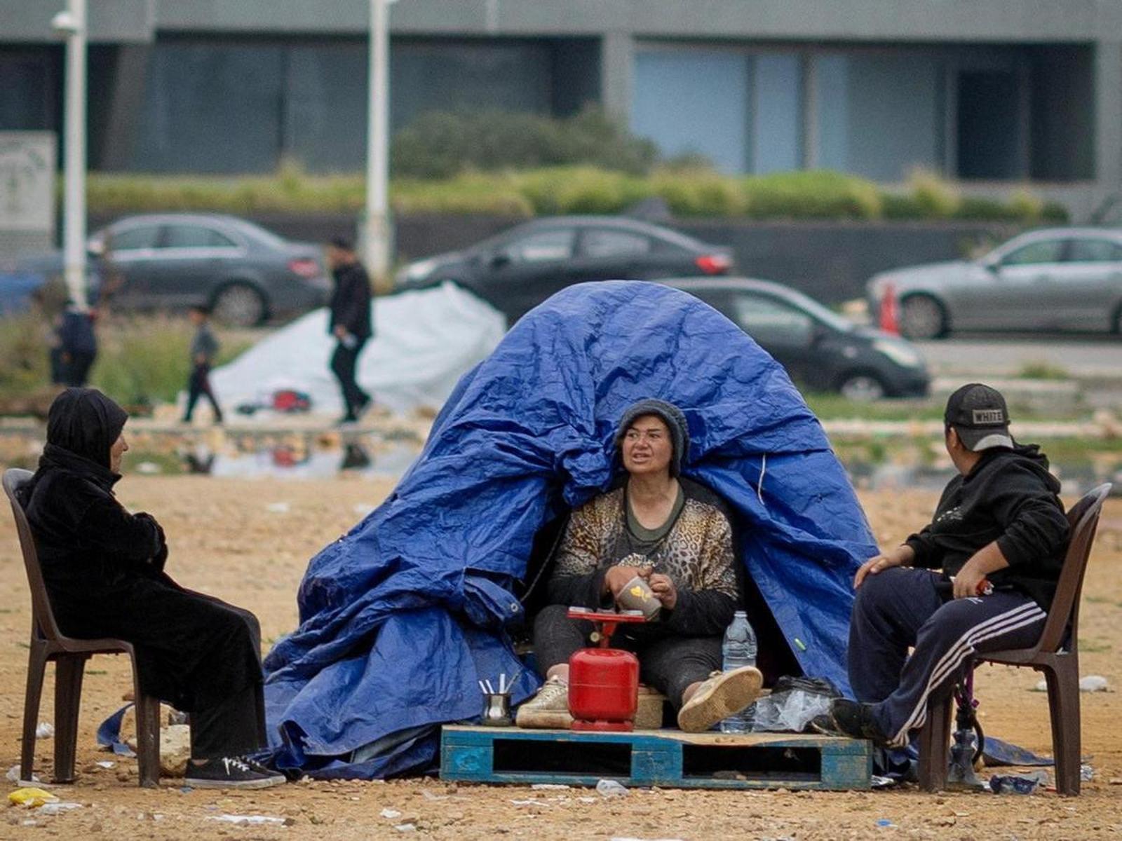 Una dona asseguda a l'interior de la seva tenda en un campament temporal per a desplaçats a Beirut.