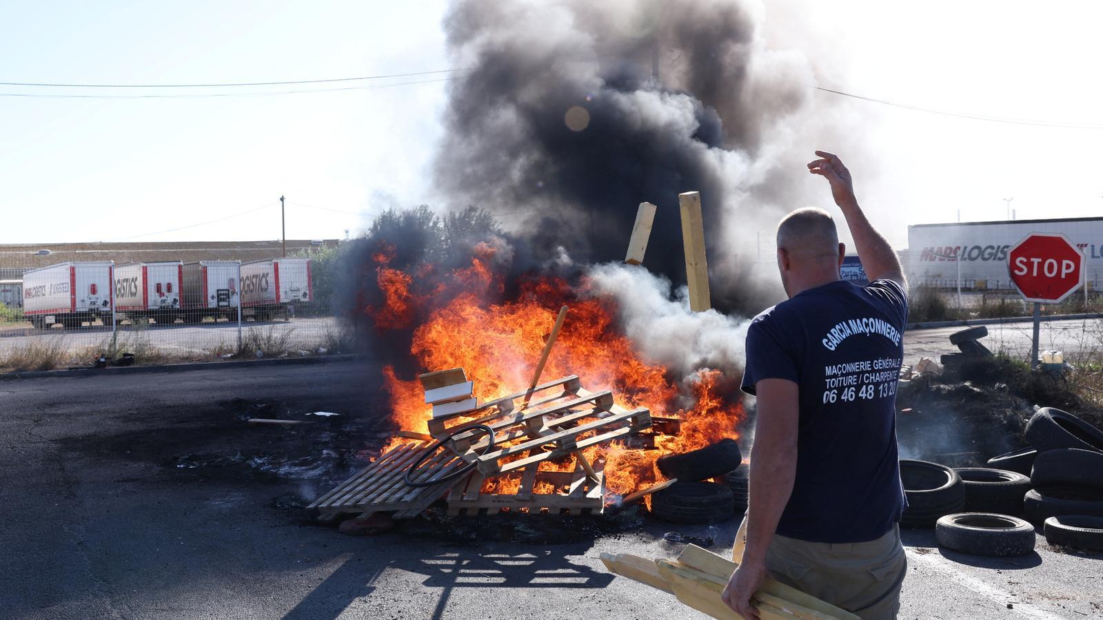 Un grupo de pescadores quema neumáticos y palés de madera para bloquear el acceso al depósito de combustible de Frontinyà en una protesta contra el aumento de los carburantes y la precarización de las condiciones de trabajo.