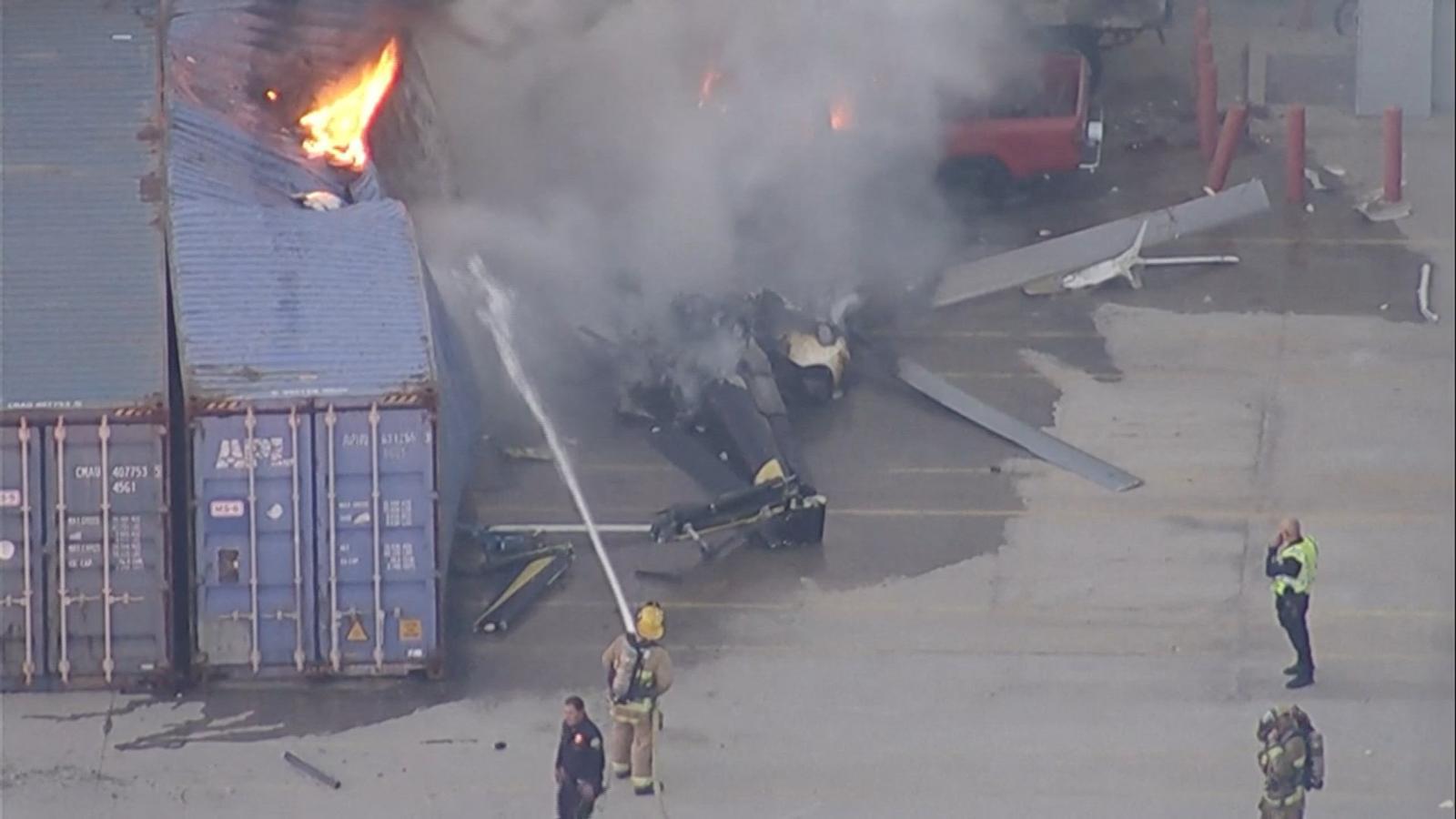 An aerial view shows firefighters working to put out the fire of the remains of an NBC News helicopter that has crashed while covering the news of a deadly bus collision in Chatsworth, Los Angeles.