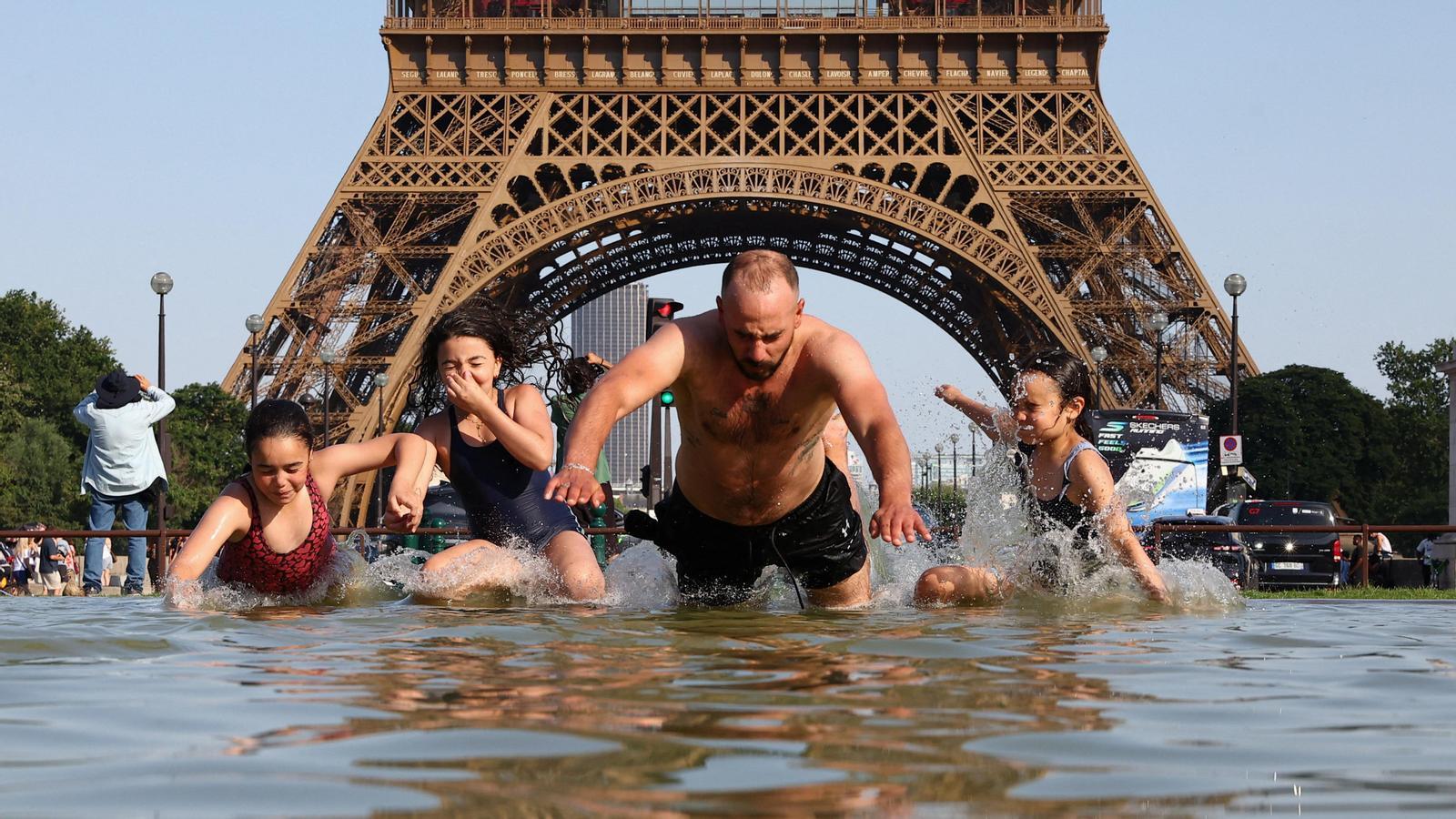 A group of people try to cool off in the Trocadero fountain, next to the Eiffel Tower. The temperature forecast for today in the French capital is 39 degrees.