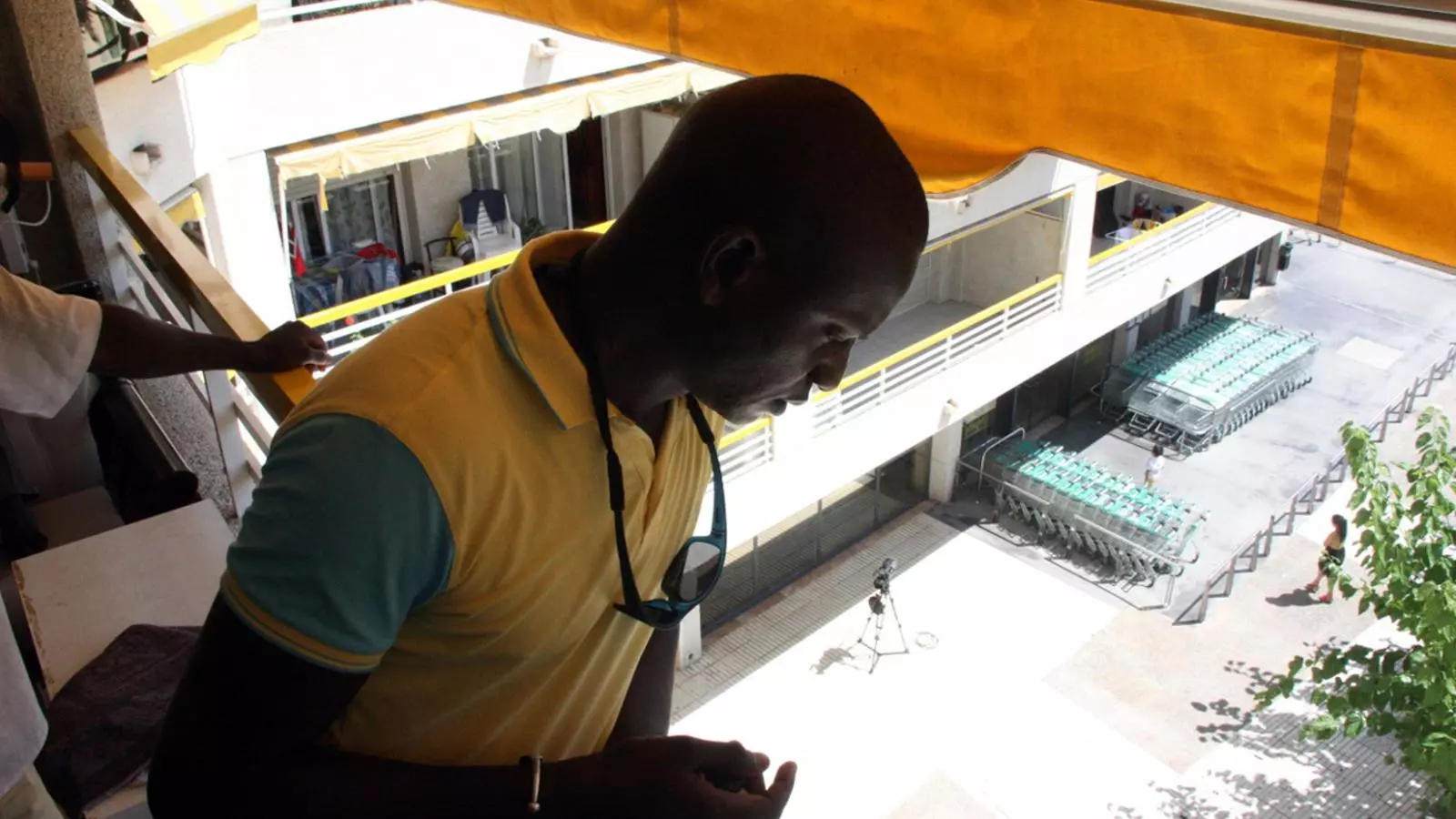 Ibrahima Sylla, germà de l'home mort a Salou, mirant cap al carrer des del balcó on es van produir els fets / ACN