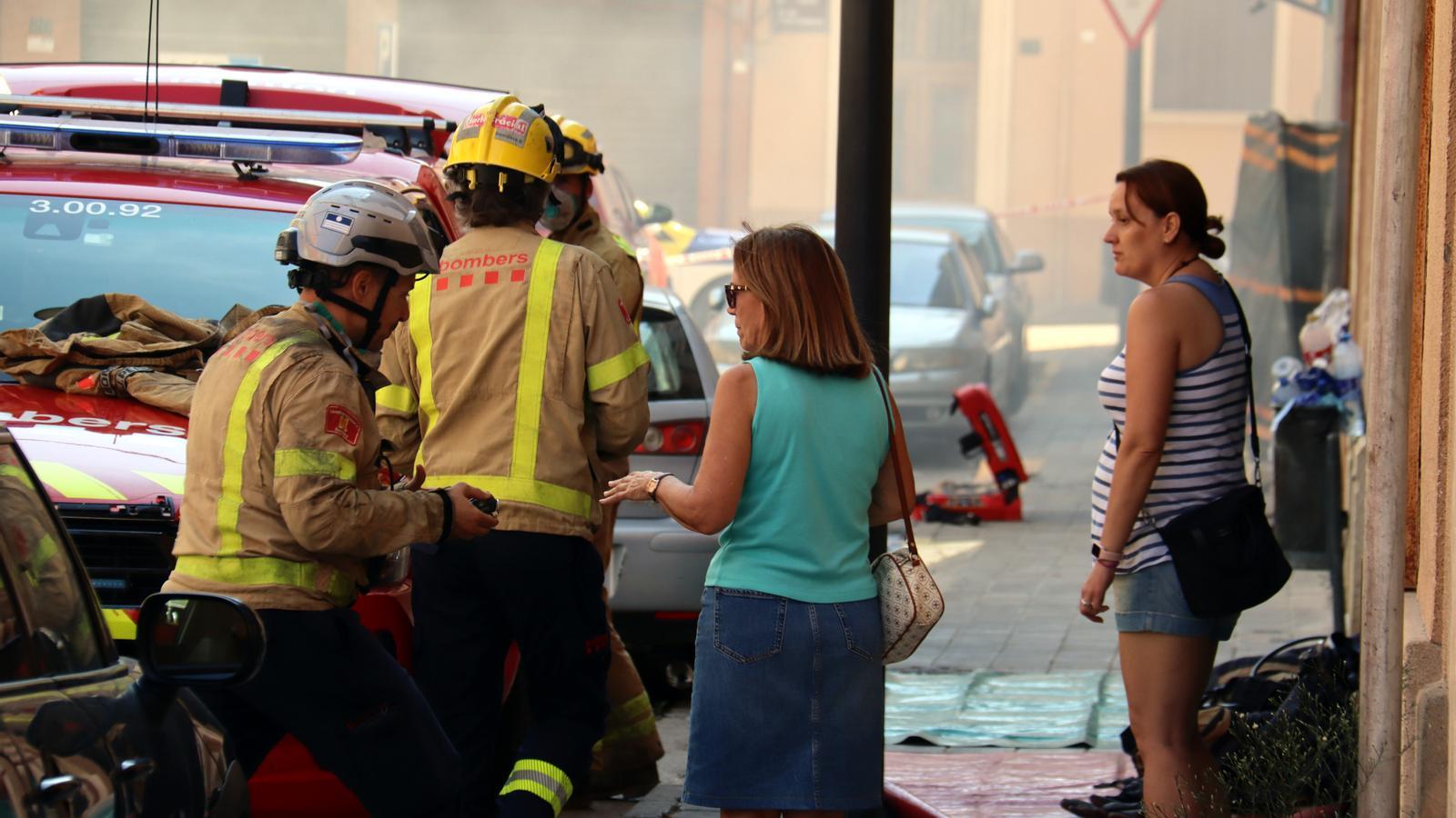 Vecinas de los edificios afectados hablando con bomberos.