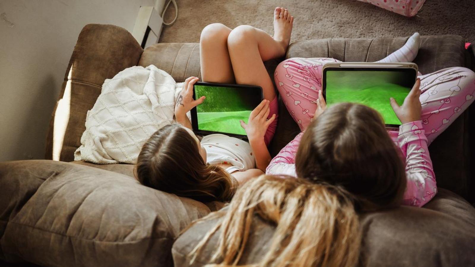 Two children looking at screens