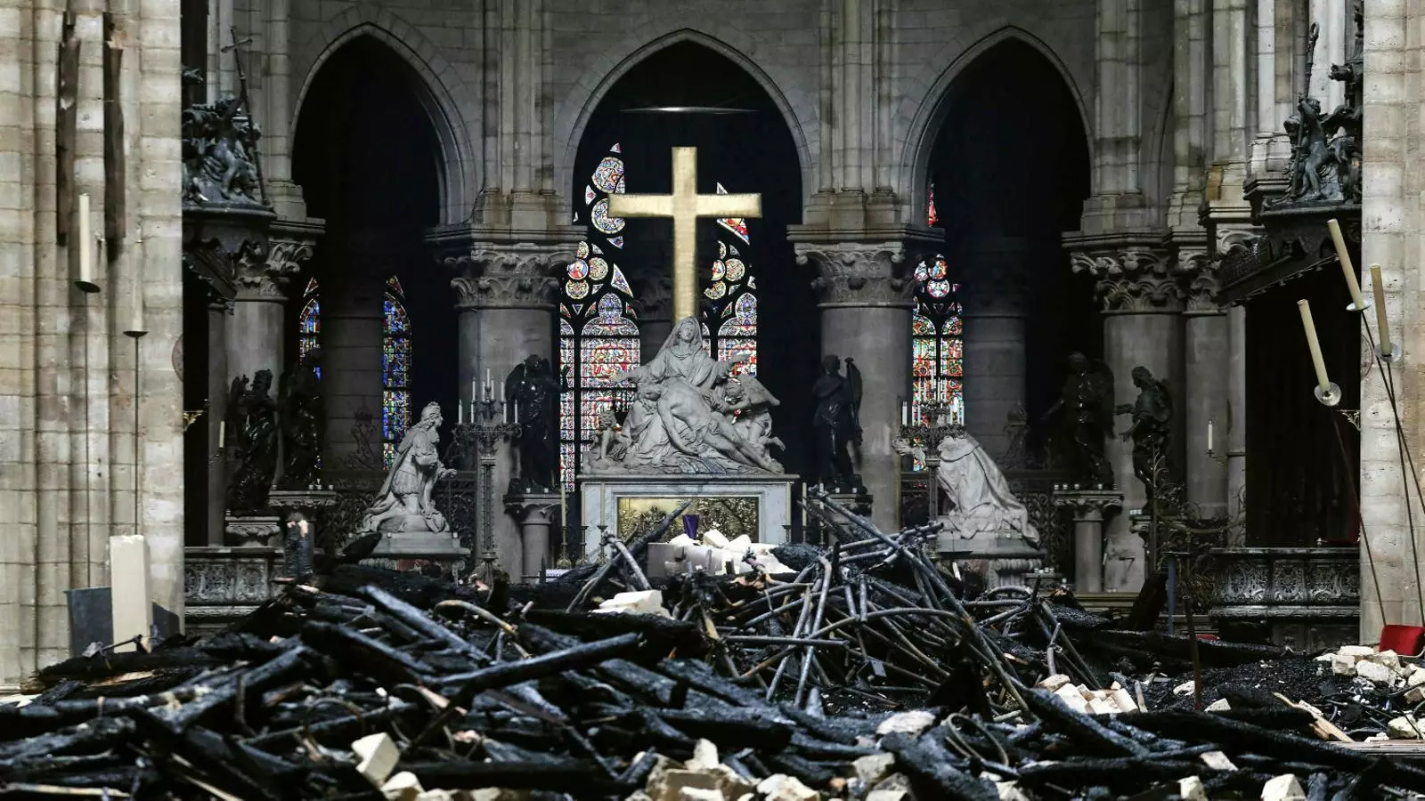 01. L’interior de Notre-Dame, ple de fustes cremades que formaven el sostre de la catedral. 02. Les bastides que es van aixecar per restaurar l’agulla, que es va ensorrar a causa del foc. 03. Operaris treballant ahir en la retirada d’una de les estàtues de la façana.