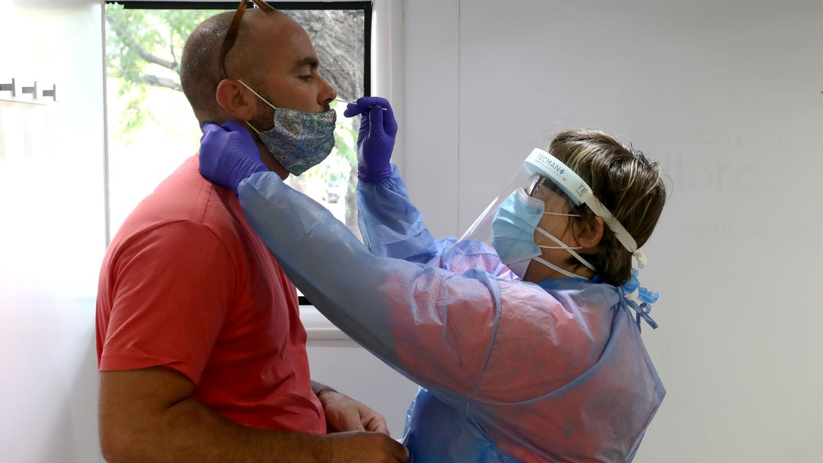 Una professional sanitària fa una PCR a un usuari.