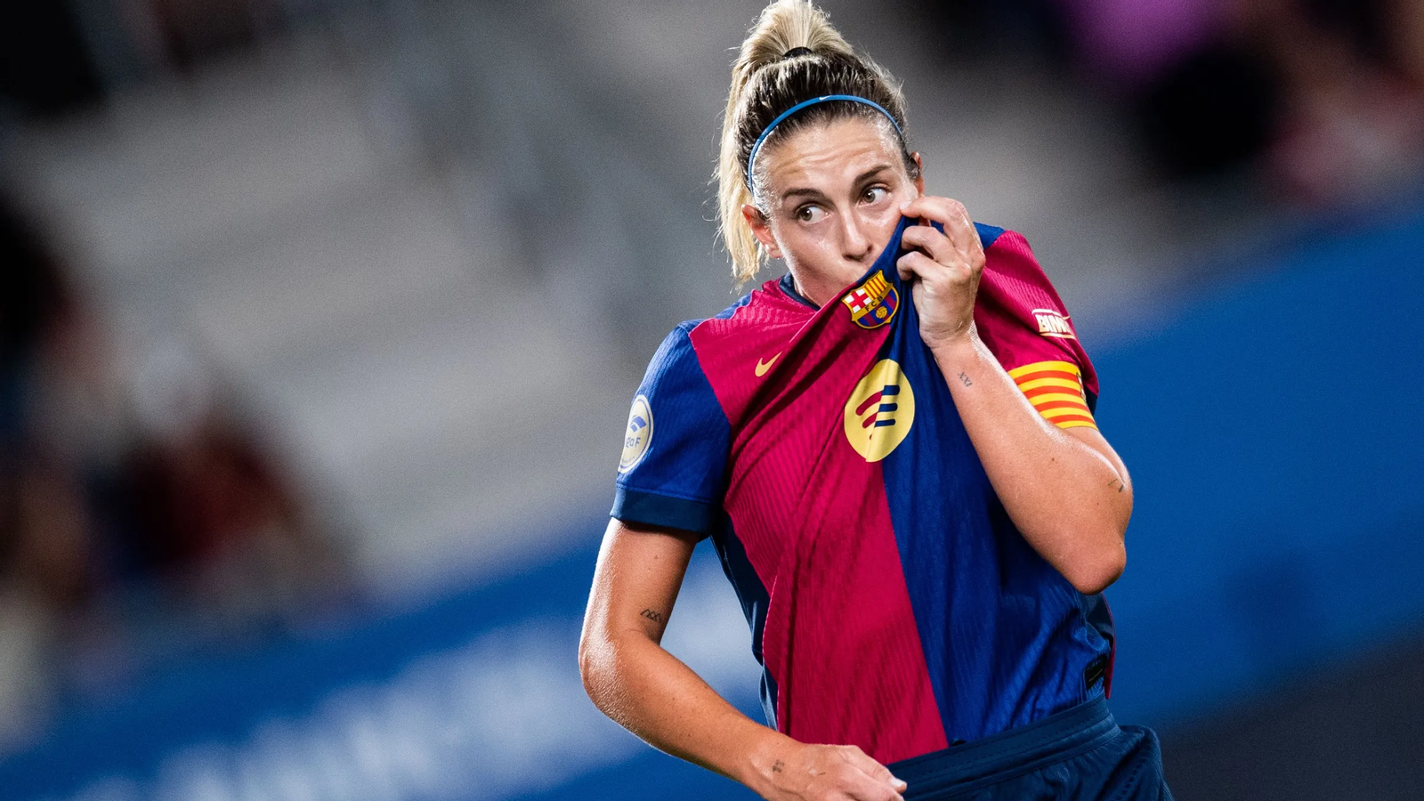 Alexia se da un beso en el escudo del Barça durante un partido