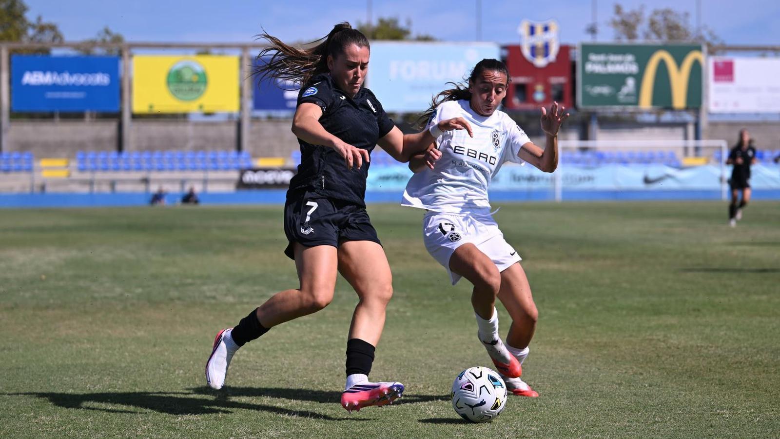 Paula Sánchez, from Badalona, fights for a ball with Laura Camino, from Real Sociedad