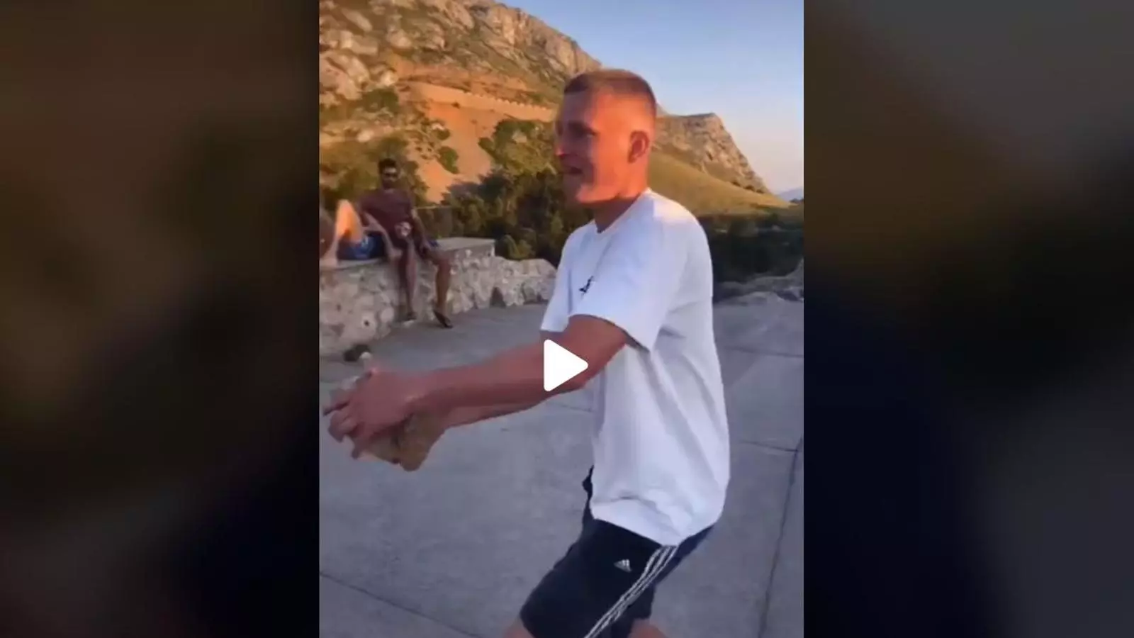 Un dels joves apunt de llançar una pedra des del mirador del Colomer.
