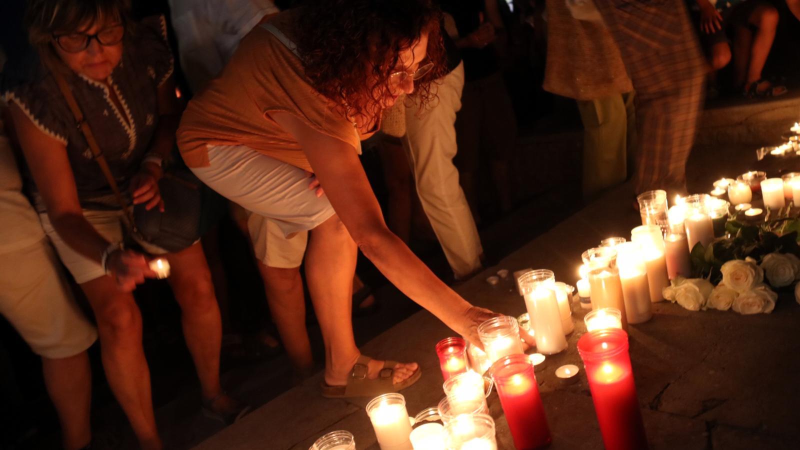 Una mujer coloca una vela en un altar laico en memoria de la víctima del apuñalamiento de Manresa.