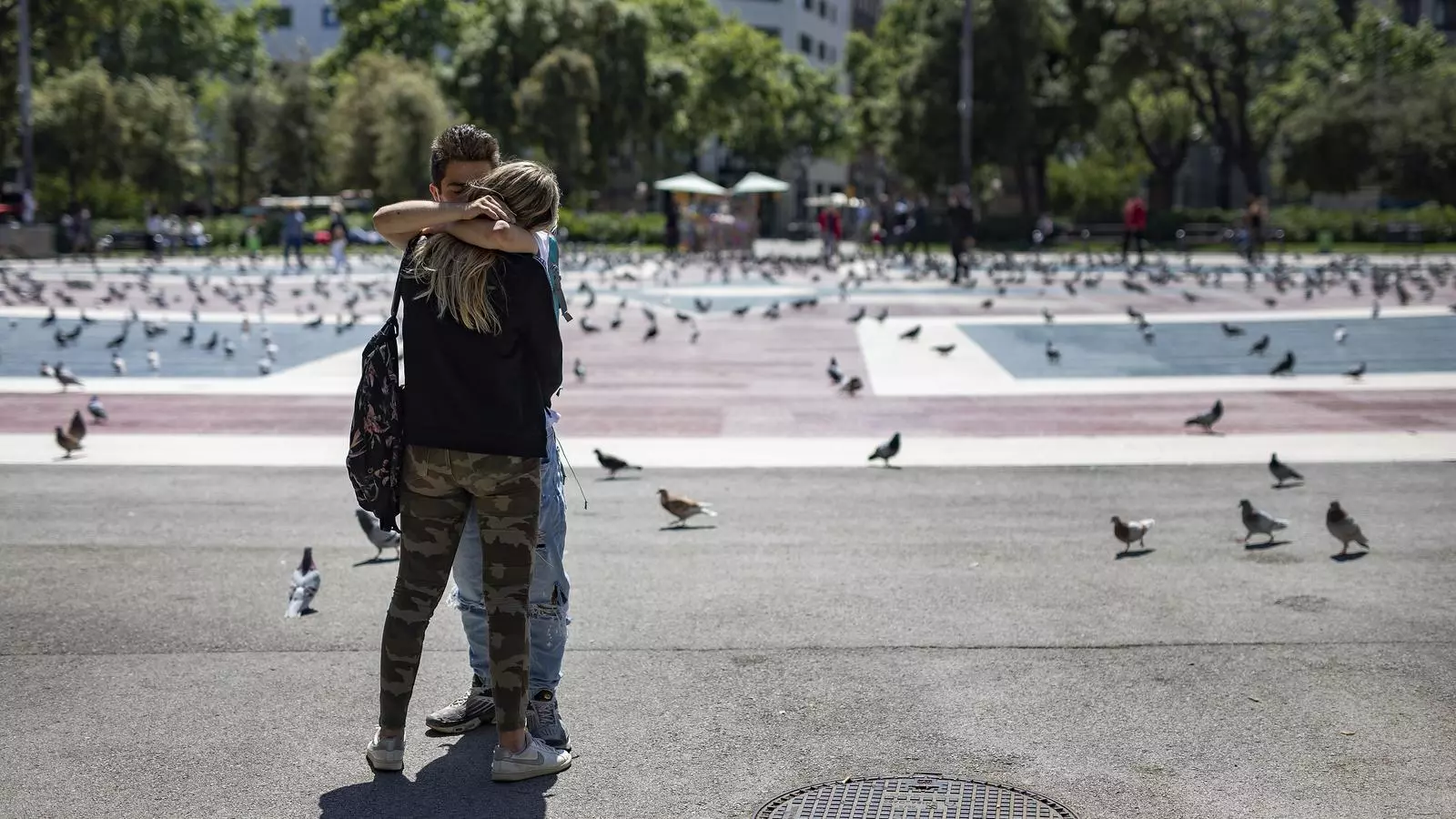 Una parella jove fent-se un petó a la plaça de Catalunya de Barcelona, en una imatge d'arxiu.