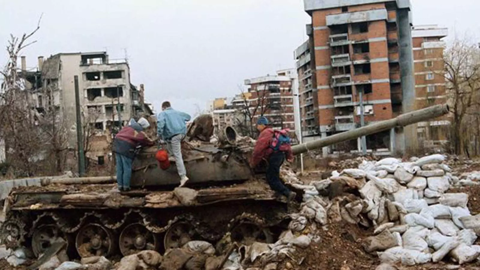 Gent escalant un tanc abandonat a la ciutat de Sarajevo / REUTERS