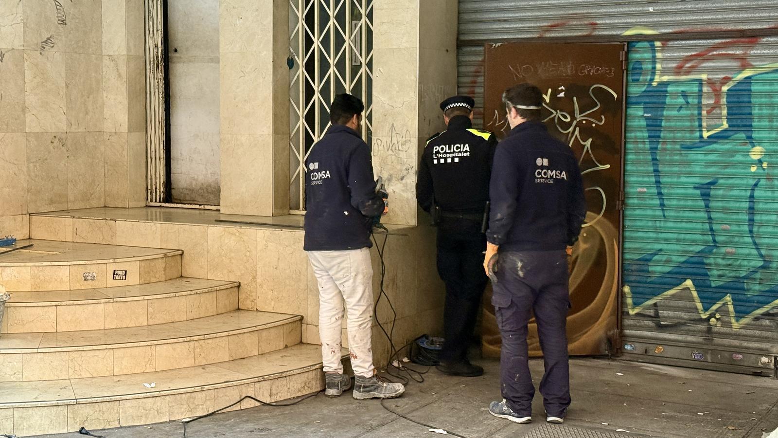 An officer from the Hospitalet de Llobregat Urban Guard enters the premises where a woman was stabbed to death.