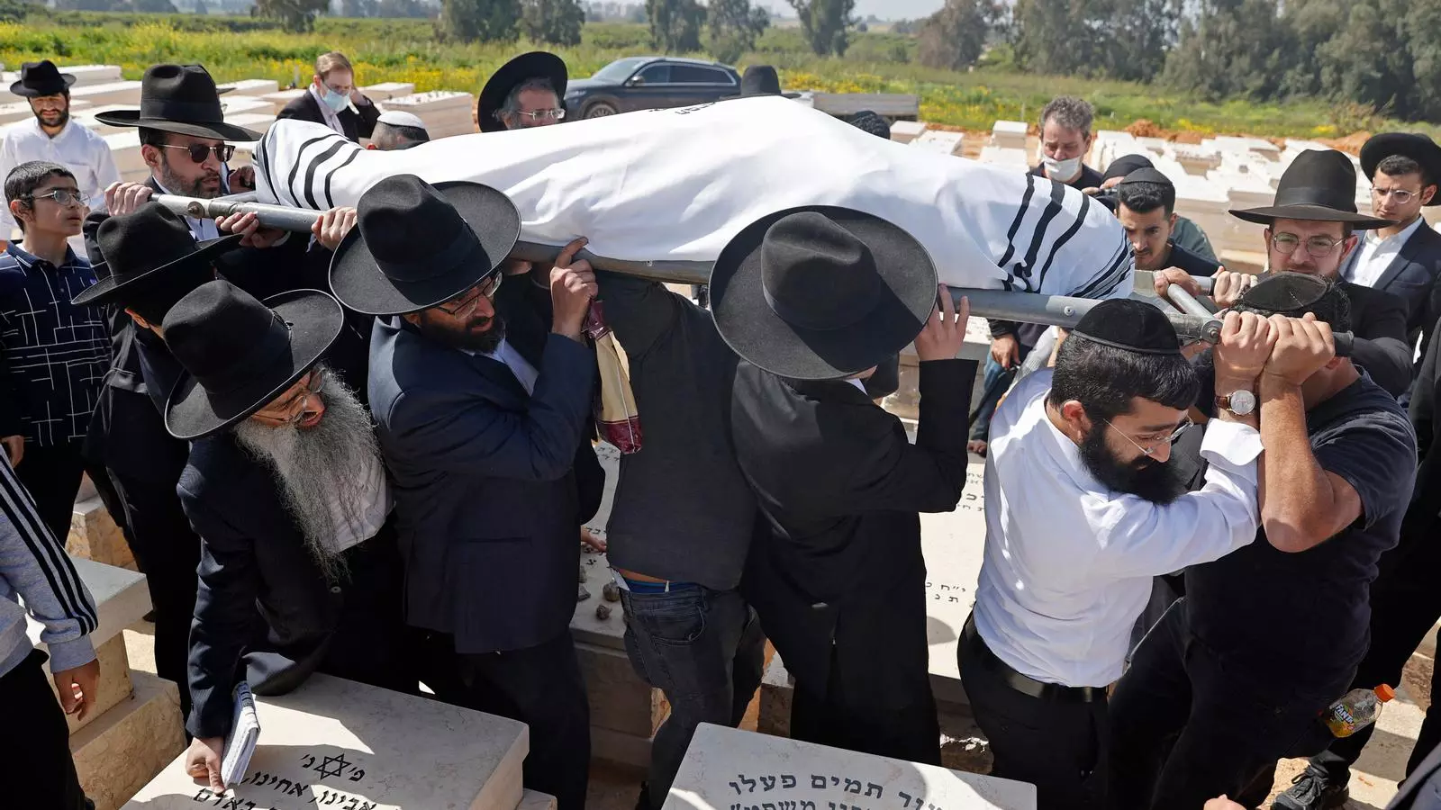 Un grup d'homes carreguen el fèretre de Yaakov Shalom una de les cinc persones assassinades.