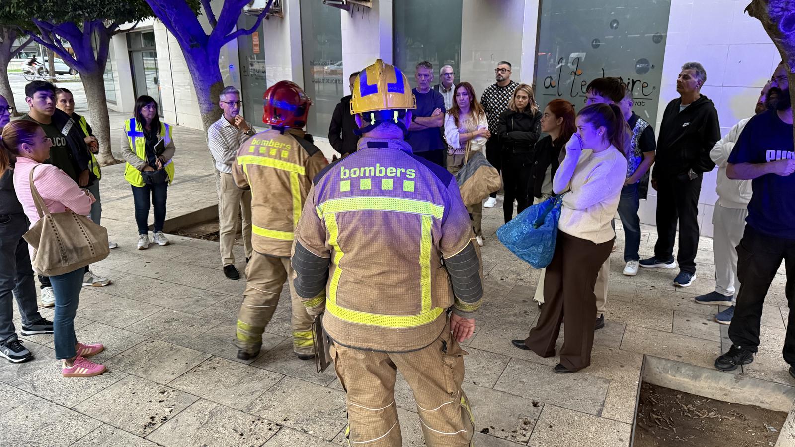 Firefighters and neighbors outside the affected building.
