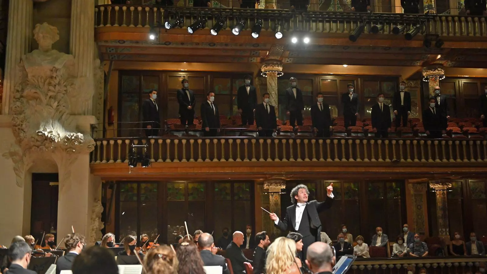 Gustavo Dudamel dirigint la Simfònica de Galícia i els cors emmascarats del Palau de Música.