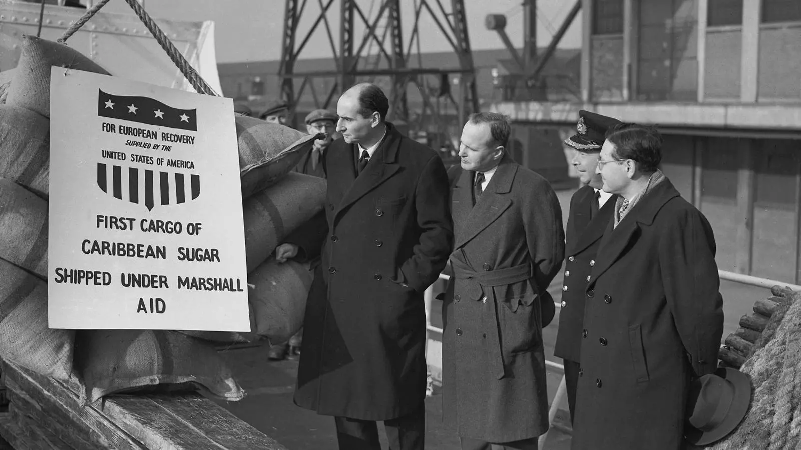 Diplomàtics britànics i nord-americans inspeccionant un carregament de sucre del Pla Marshall als molls de Londres el 1949.