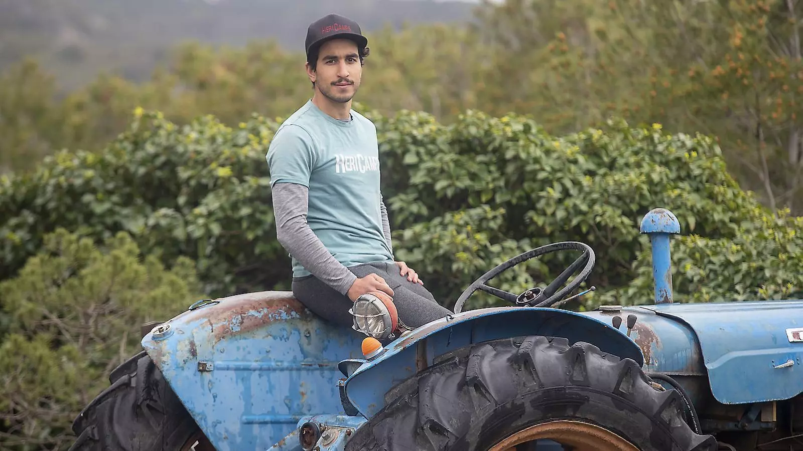 A dalt Maria Piñol al despatx que té muntat a casa seva i, a baix, Heribert Cubells treballant amb el tractor.