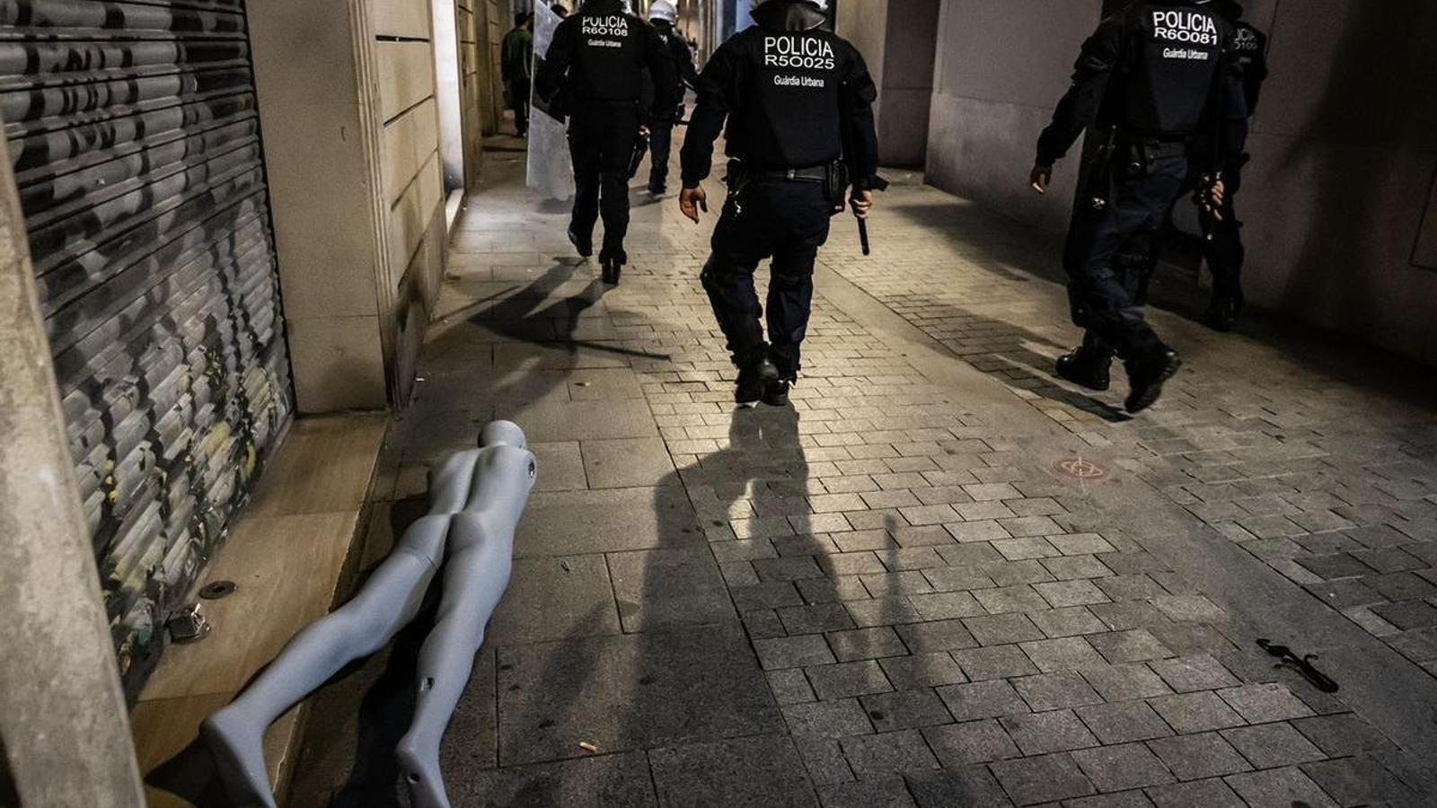Guàrdia Urbana agents pass by a vandalized mannequin in the center of Barcelona, Saturday, October 24.