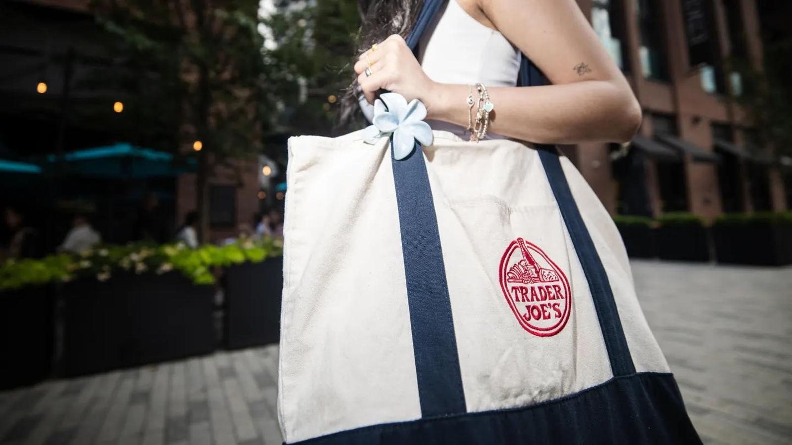 Una persona con la tote bag de Trader Joe's