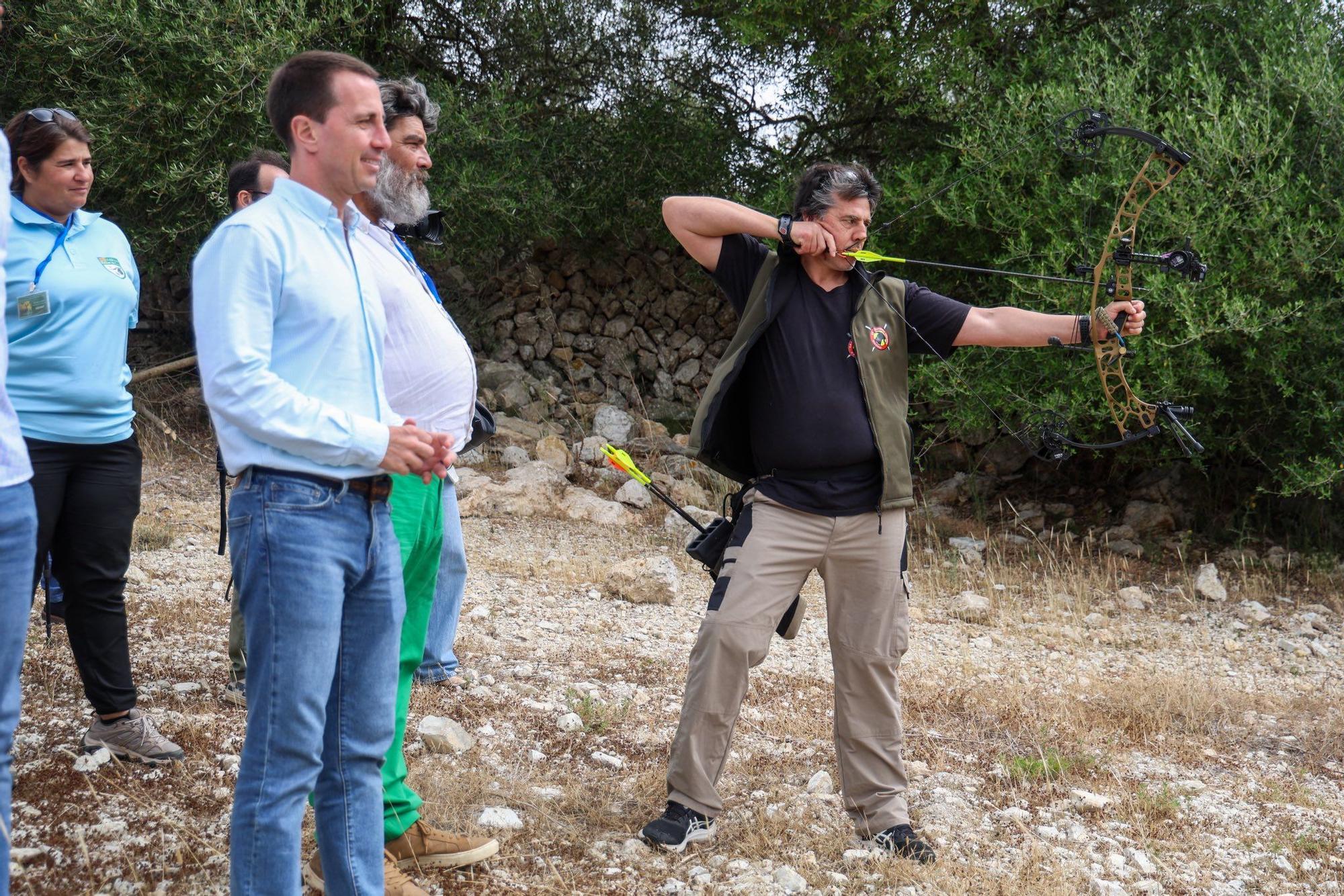 El president del Consell, Llorenç Galmés, acompanyat del conseller de Medi Ambient, Pedro Bestard i un dels participants fent una demostració de tir
